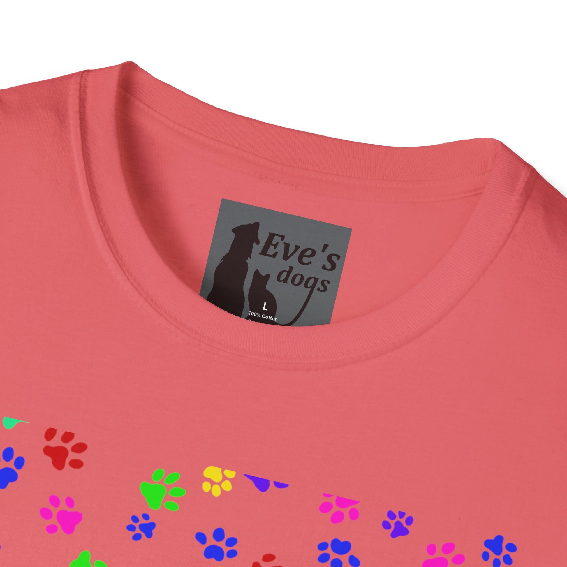 This is the Coral Silk Adopt Eve's Dogs T-Shirt. It comes in XS - 5XL. This is an upclose image of the shirt where the neck/tag is. The size label is a grey and black tag with a dog and cat with the "Eve's dogs" writing. The sizes and shirt product materials are printed in white. There is a little bit of paw prints on the front.  The colors are pink, green, blue, purple, red paw prints in different sizes. It is against a white background.