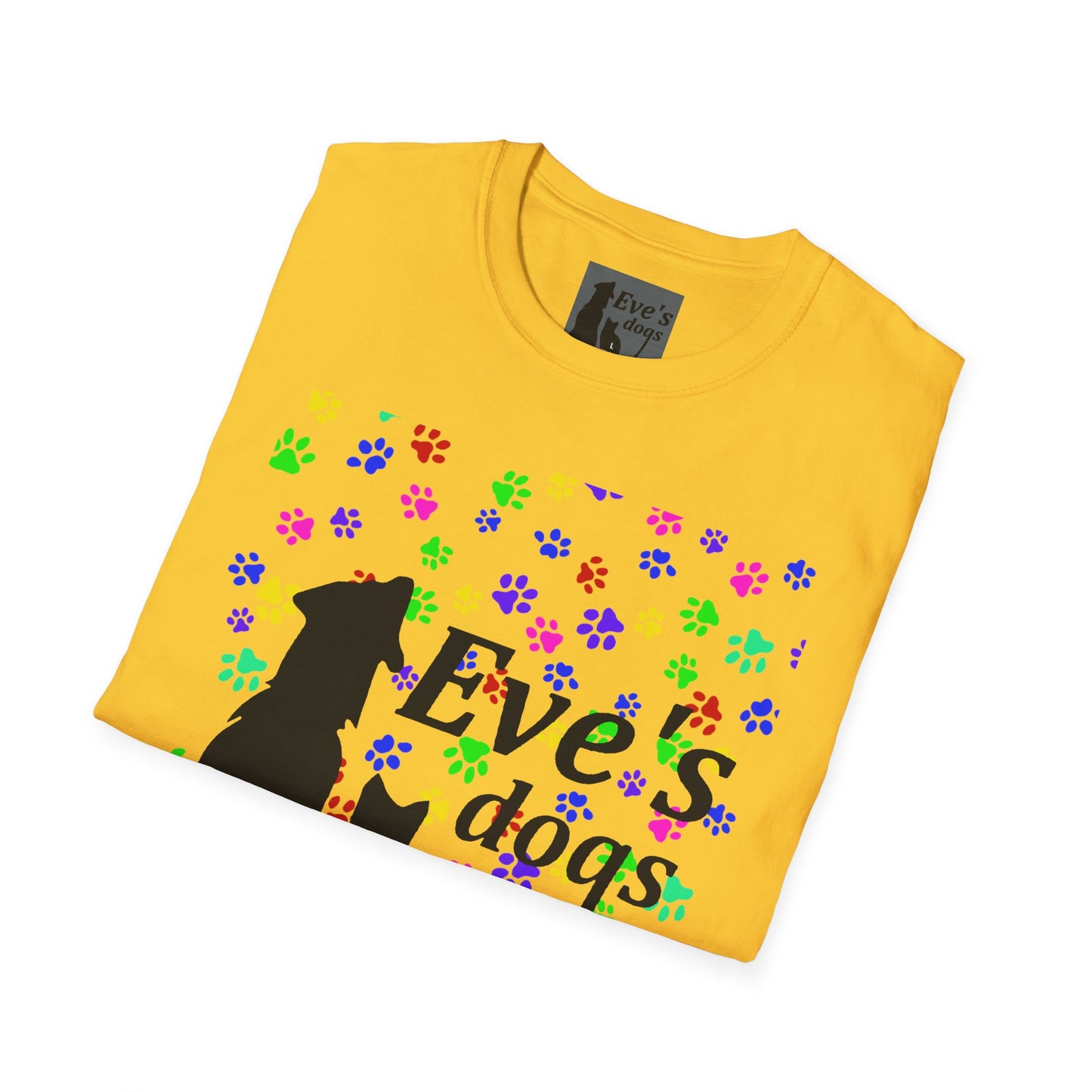 This is the Daisy Adopt Eve's Dogs T-Shirt. It comes in XS - 5XL. The image is the shirt folded and showing the front. The size label is a grey and black tag with a dog and cat with the "Eve's dogs" writing. The front has pink, green, blue, purple, red paw prints in different sizes. Also, the dog and cat with "Eve's dogs" printed in black. It is against a white background.