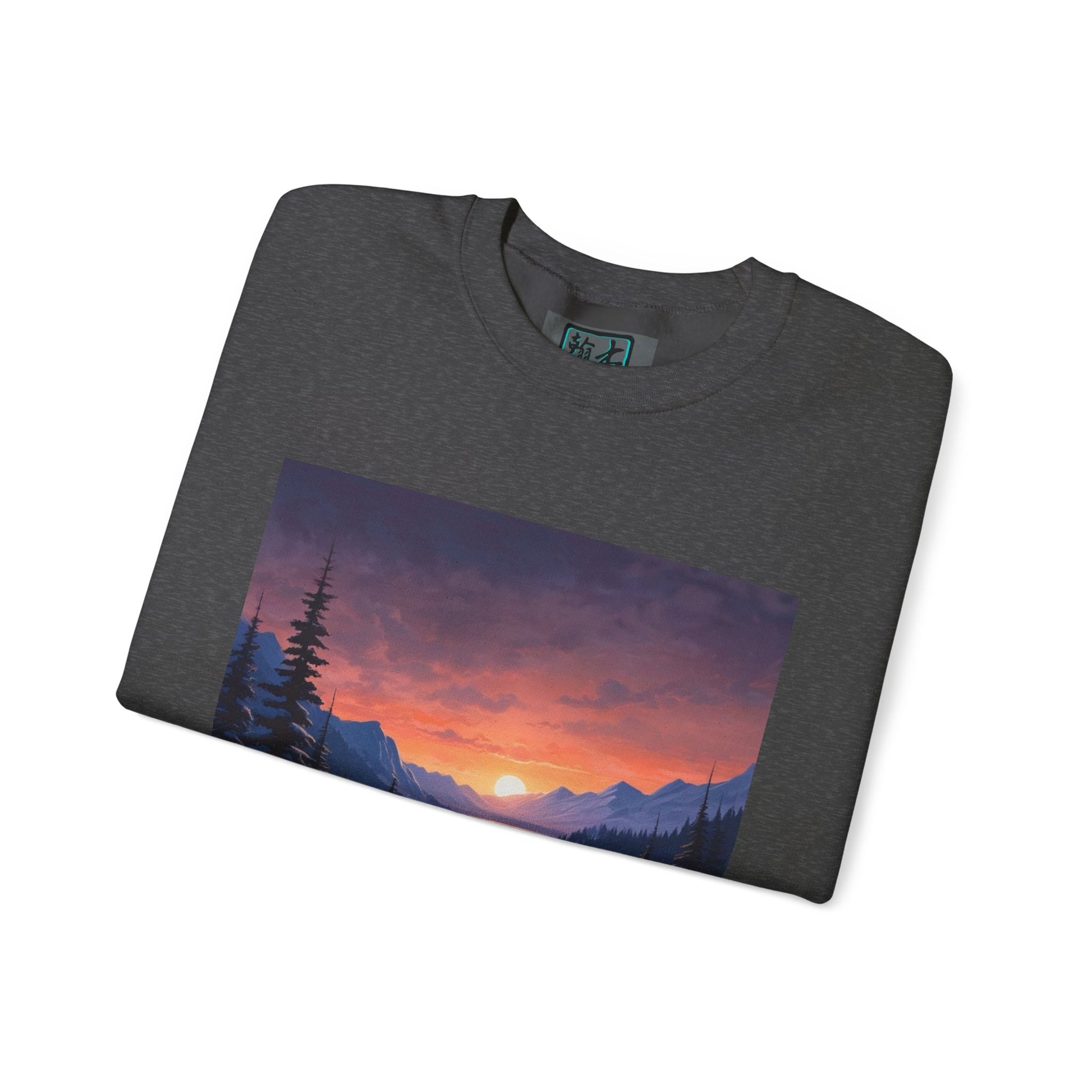 This is the Dark Heather Snow Valley Sweatshirt that is a crewneck coming in S - 5XL sizes. The crewneck is folded and against a white background. This design is by Lee Hansheng Studios and showcases the sun rising past the horizon and consist of yellow, orange, red hues which is illuminated onto the tips of the dark green pine trees and the wispy clouds. Further in the background the mountain tops line the horizon. The size label is printed on the inside with the studio logo outlined in blue and black.