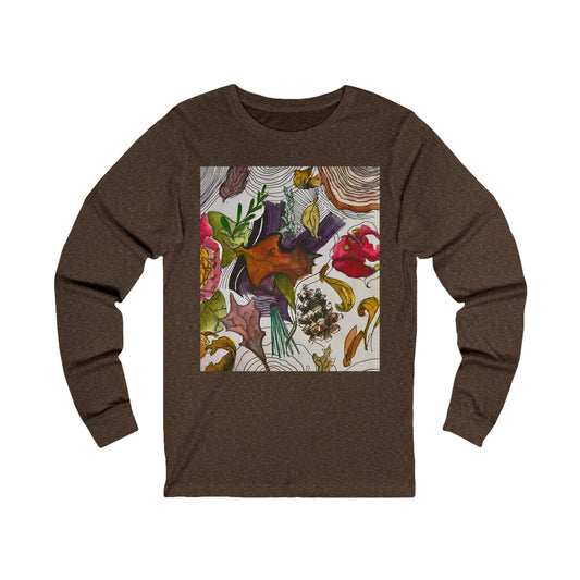 This is the Heather Brown Fall is falling Long Sleeve by Storm Garden Studio. This is showcasing the front of the long sleeve. The illustration on the front is within a rectangle starting from the collarbone area to below the belly button. There are various conifers like leaves, pine cones, etc. There are also some flowers and a tree trunk ring. The colors are red, yellow, dark brown, purples, and green. The shirt is against from a white background.