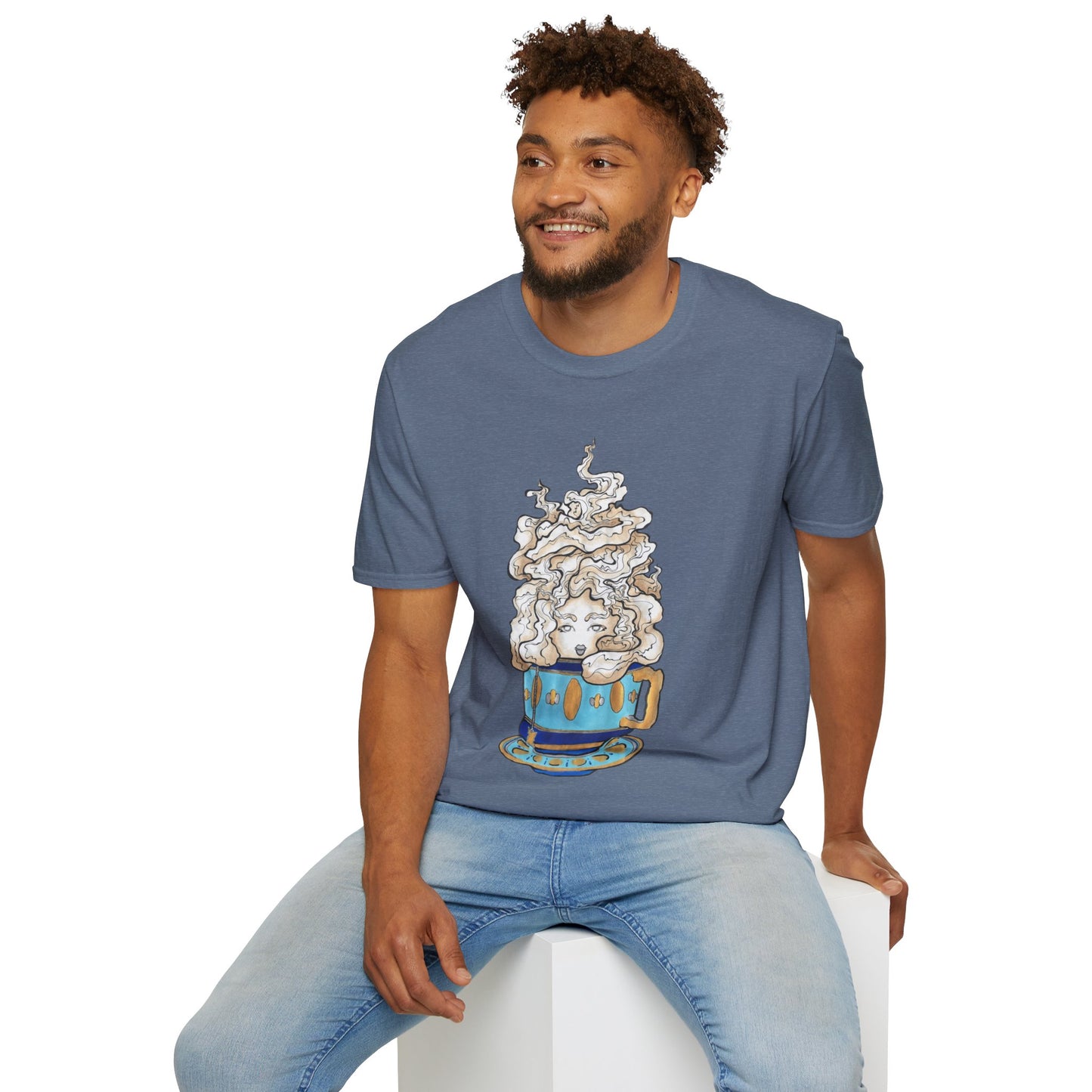 This is the Heather Indigo Earl Grey Softstyle T-Shirt by Chris Foster Design. It comes in sizes XS-5XL. The illustration is of a gold, light blue and dark blue teacup with a tan, yellow and white steam. The steam is swirly and goes up and outwards. In the middle is a lady's face. A smiling man sitting on a white podium with one hand on the back edge, light jeans, looking to the left and wearing the t-shirt. 