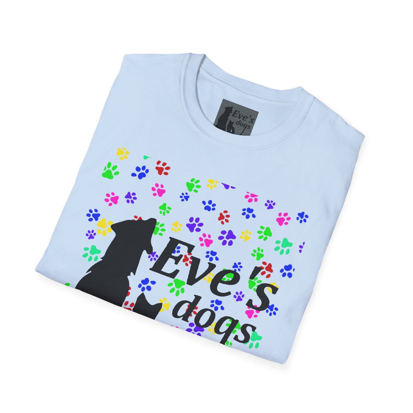 This is the Light Blue Adopt Eve's Dogs T-Shirt. It comes in XS - 5XL. The image is the shirt folded and showing the front. The size label is a grey and black tag with a dog and cat with the "Eve's dogs" writing. The front has pink, green, blue, purple, red paw prints in different sizes. Also, the dog and cat with "Eve's dogs" printed in black. It is against a white background.