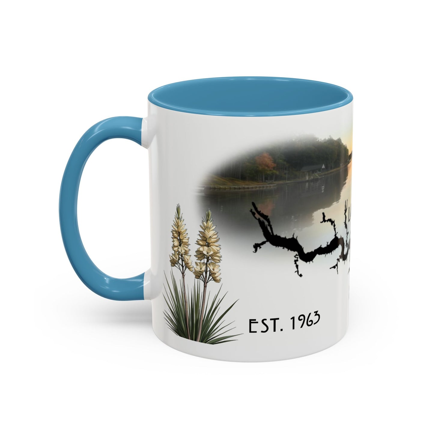 This is the 11oz Light Blue Lake Gaston Mug. It is an illustration by Lee Hansheng Studios. The picture is shown from the left side of the mug. The handle and inside of mug are color matched too. The mug is all white except for the illustration and handle. The illustration shows some yucca plants on the left, serene depiction of the lake in the back, the shadow of a tree and "EST.1963". The mug is against a white background in the picture too.