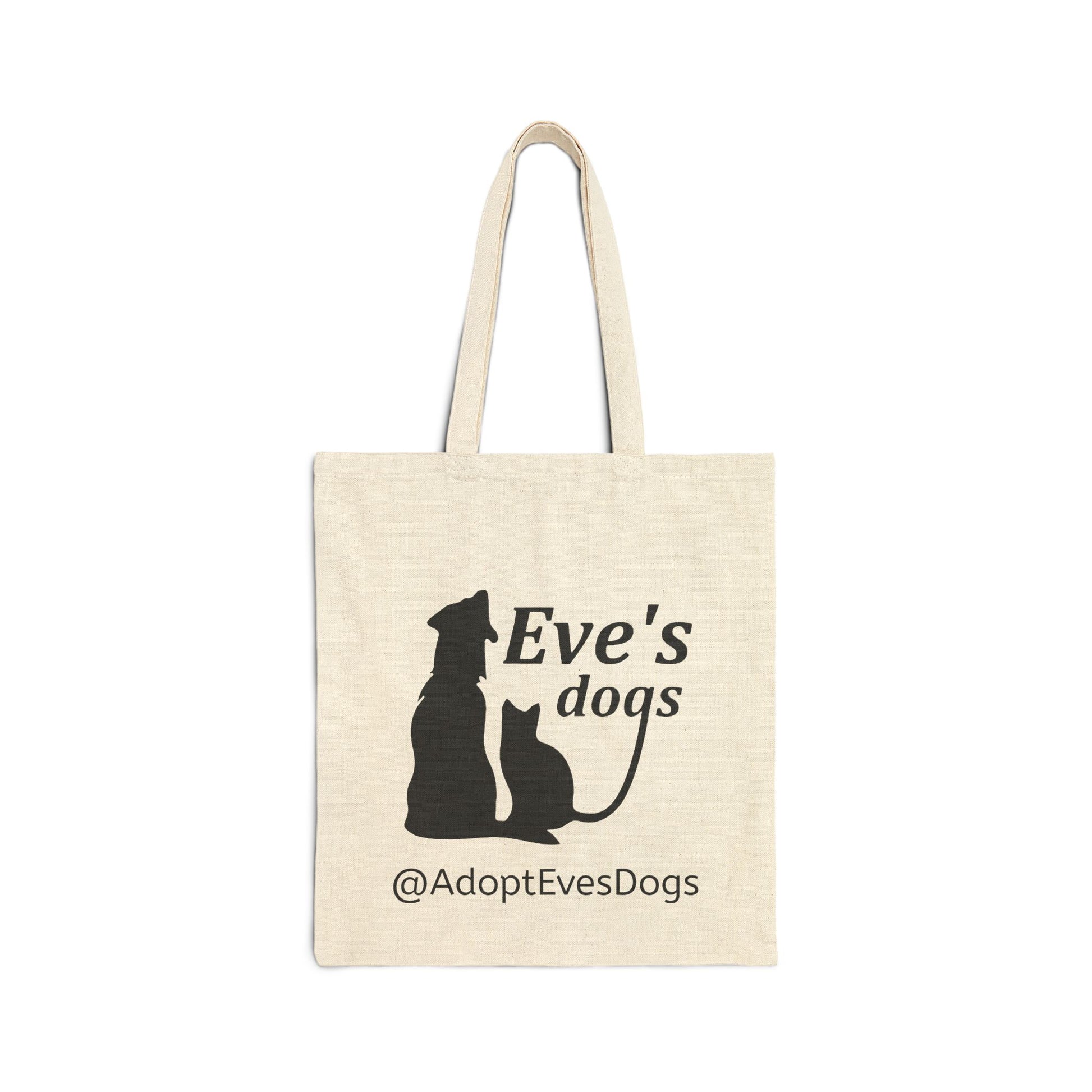 This is the Natural 15" x 16" Eve's Dogs Canvas Tote. The tote has a picture of a cat and dog in black. There is a print that says, "Eve's dogs and @AdoptEvesDogs" in black. 