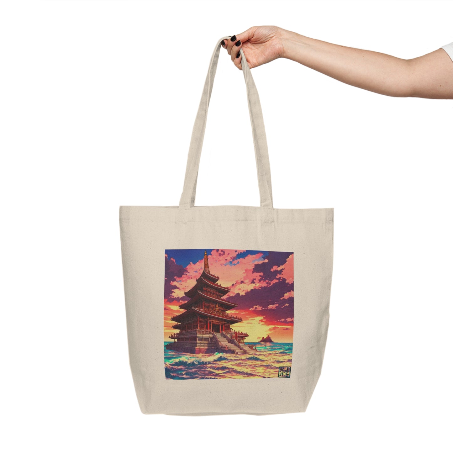 This is the 18" x 15" Temple on the Sea Shopping Tote by Lee Hansheng Studios.  The illustration has a temple with 4 stories on the left. There are cloudy skies with a little bit of blue, white, red and pinks on the clouds. There is a little bit of the sunset peeking through behind the temple. It is yellow and red colors. The image shows the front of the tote. A lady's upper arm is shown with black nails on the right and is holding the shopping tote by the handles. The image is against a white background.