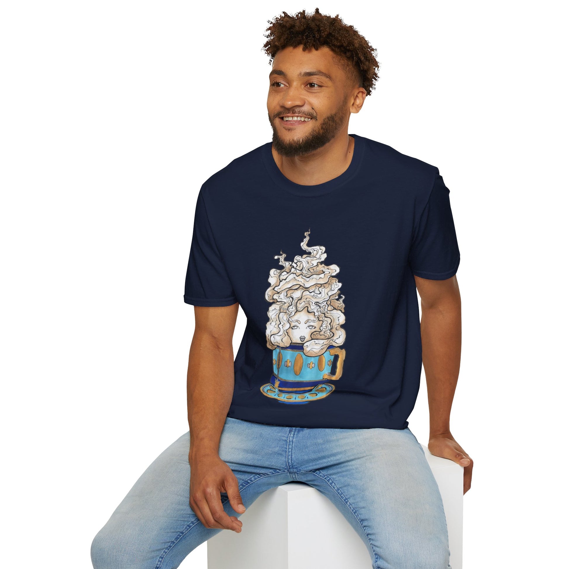 This is the Navy Earl Grey Softstyle T-Shirt by Chris Foster Design. It comes in sizes XS-5XL. The illustration is of a gold, light blue and dark blue teacup with a tan, yellow and white steam. The steam is swirly and goes up and outwards. In the middle is a lady's face. A smiling man sitting on a white podium with one hand on the back edge, light jeans, looking to the left and wearing the t-shirt. 