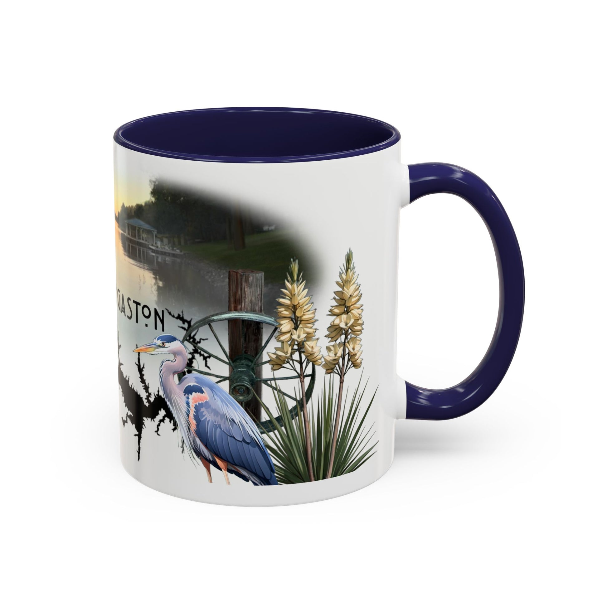 This is the 11oz Navy Lake Gaston Mug. It is an illustration by Lee Hansheng Studios. The picture is shown from the right side of the mug. The handle and inside of mug are color matched too. The mug is all white except for the illustration and handle. The illustration shows two yucca plants on the right, a great blue heron and a green wheel that is attached to a log. The mug is against a white background in the picture too.