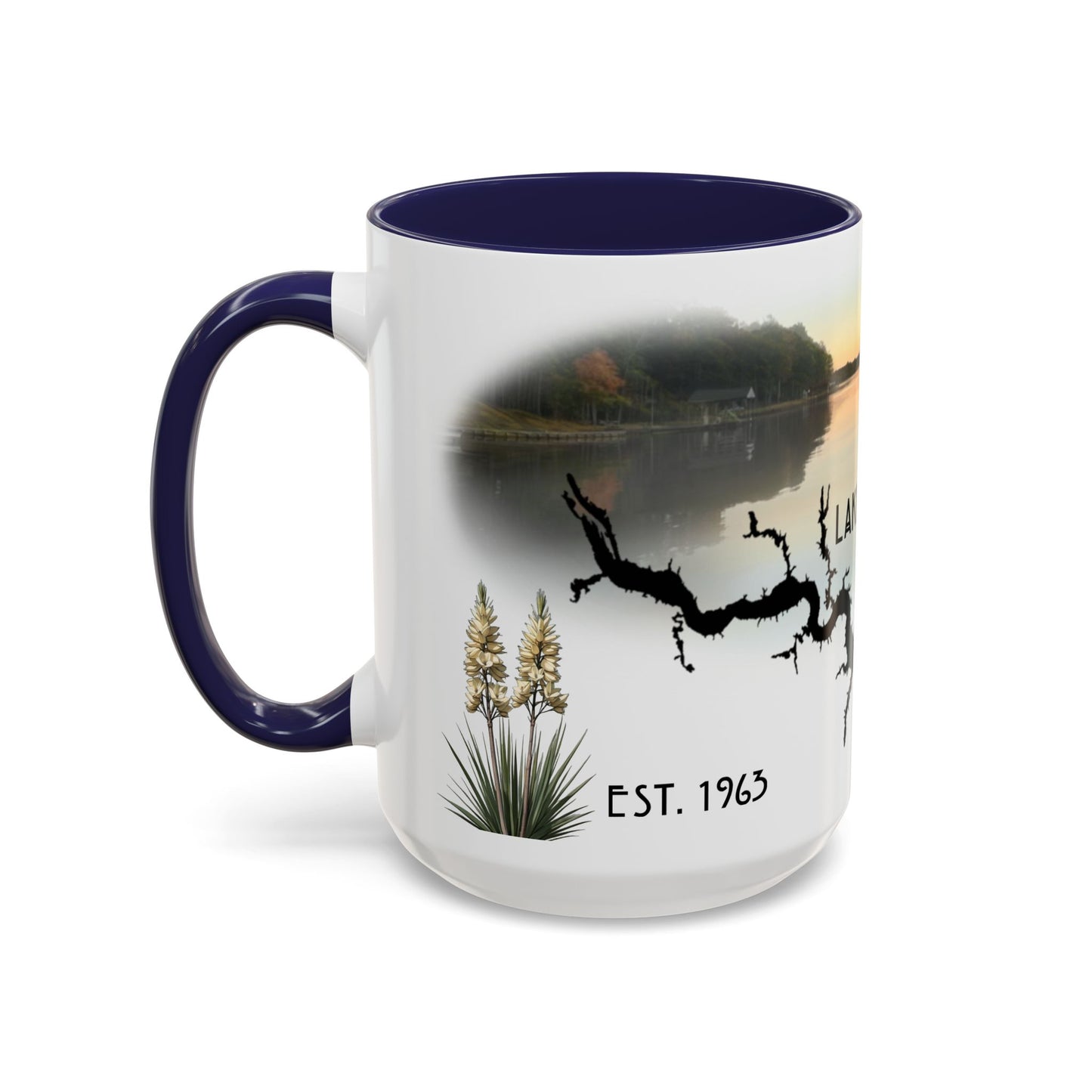 This is the 15oz Navy Lake Gaston Mug. It is an illustration by Lee Hansheng Studios. The picture is shown from the left side of the mug. The handle and inside of mug are color matched too. The mug is all white except for the illustration and handle. The illustration shows some yucca plants on the left, serene depiction of the lake in the back, the shadow of a tree and "EST.1963". The mug is against a white background in the picture too.