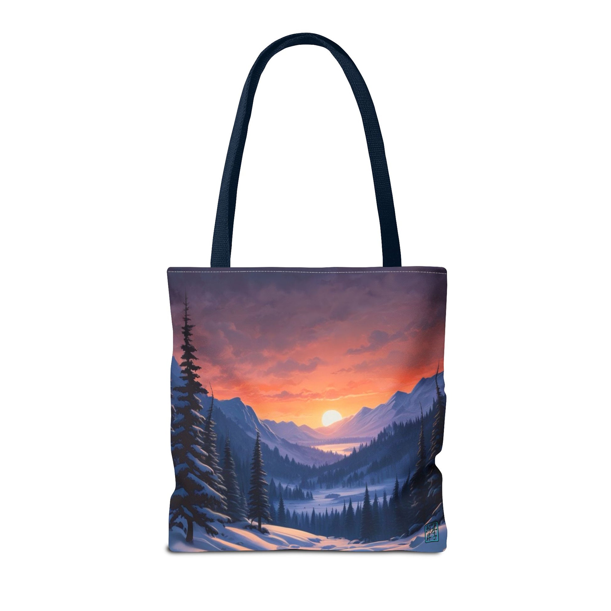 The Navy 16" x 16" Snow Valley Tote Bag has color matched handles. The tote is against a white background.The design by Lee Hansheng Studios showcases a snowy hill/mountain area with large pine trees on both sides continuing into the horizon. The sun rises past the horizon consisting of yellow,orange,red hues illuminating onto wispy clouds,snowy field, mountains and dark green pine trees. 