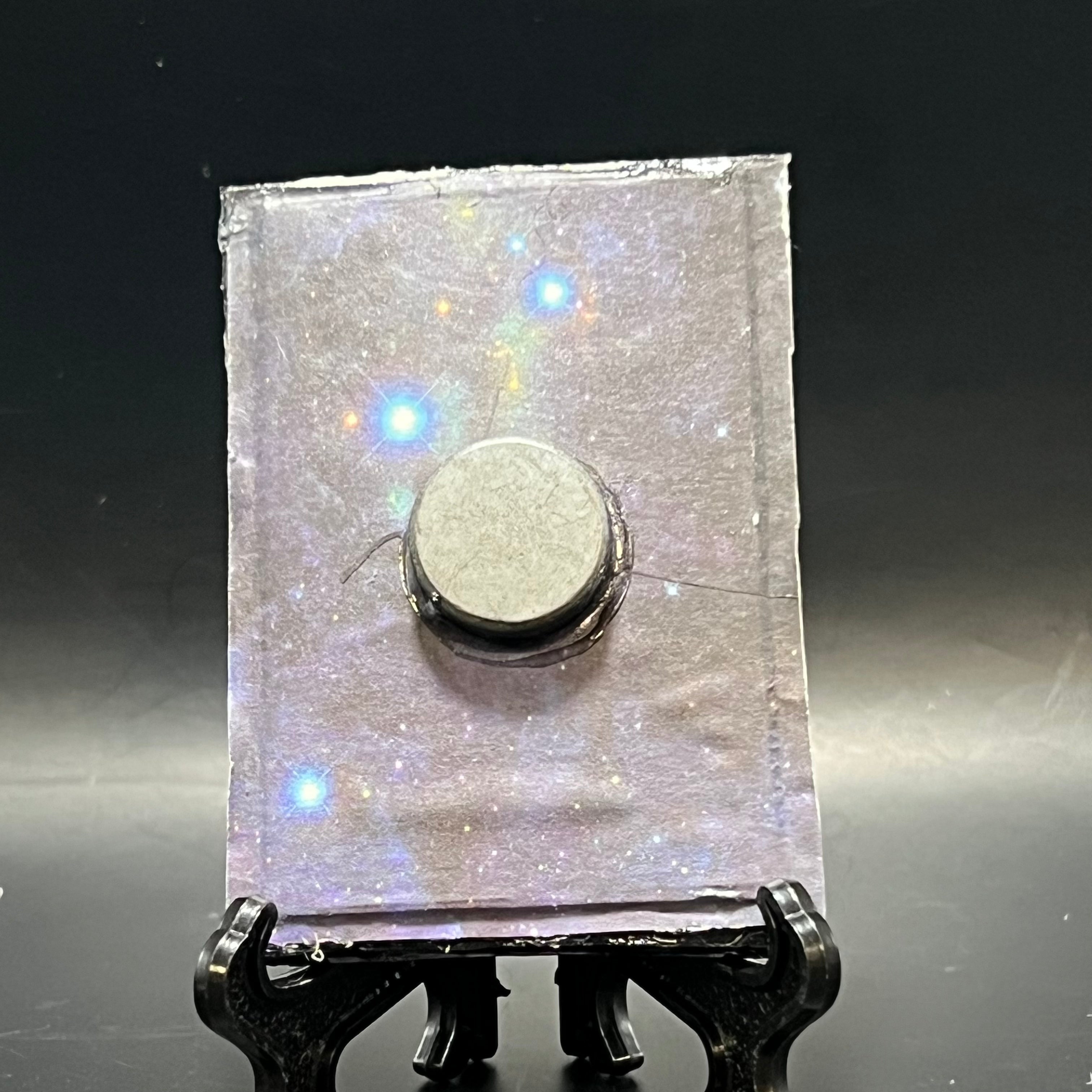 Close-up of the Saturn In Retrograde miniature painting’s textured brushstrokes and subtle color blending on the detailed