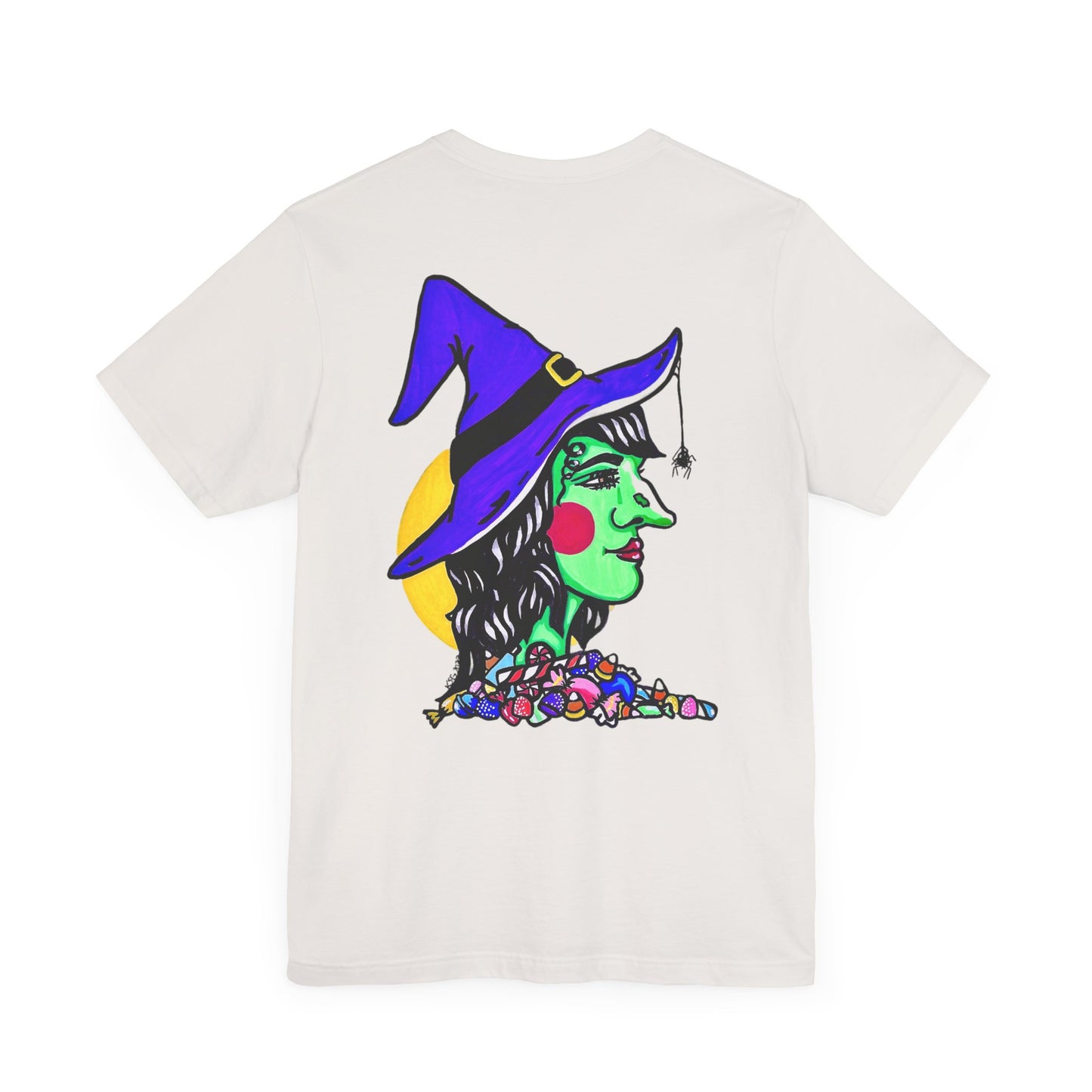 This is the Vintage White Trick or Treat! Witch T-Shirt by Storm Garden Studio. This is the back of the shirt. It shows the side profile image of a witch. She is facing the right side. She has a purple witch hat with a black belt, yellow buckle, a spider crawling down the front, red rosy cheeks, red lips and assorted candy under the neck. Behind her is a bright yellow circle past her hair. 