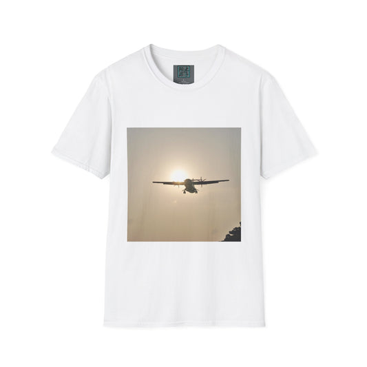 This is the White Landing T-Shirt by Lee Hansheng Studios. This is an image of the front folded. On the inside of the shirt is the logo for the studio printed in black outlined in blue, gray size label with the print being white. The illustration is a rectangular design of an airplane landing. There is an orange/yellow sun with the shadowed plane. Some trees on the right end corner. The shirt is against a white background.