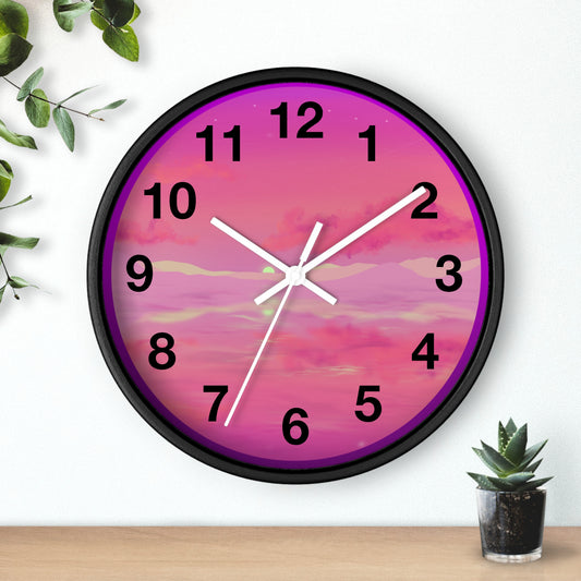 This is the 10" Black Base Pink Dreamscape Wall Clock with white hands by Lee Hansheng Studios.The front of the image with two white clock hands, black numerals and the illustration behind it.The illustration has the sky and clouds. Different pinks and hues blended into the clouds and spreads outwards.There are dark purples on the side and yellows near the middle of the art piece. It is on a white background with leaves to the left, succulent plan on the right with a wooden board. 