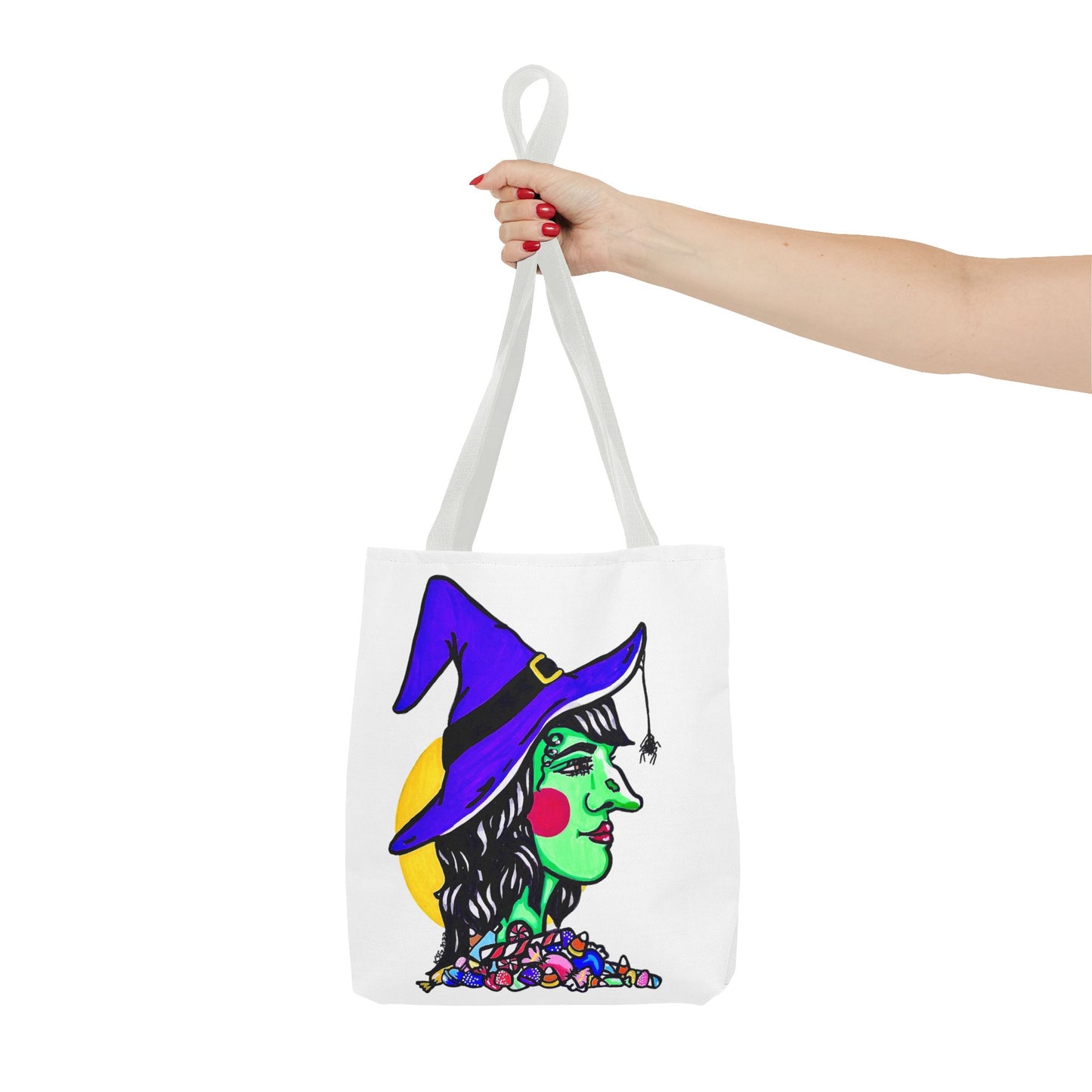 This is the White 13" x 13" Witch Tote Bag by Storm Garden Studio.The handles are color matched.It shows the side profile image of a witch.She is facing the left side.She has a purple witch hat with a black belt, yellow buckle, a spider crawling down the front, red rosy cheeks, red lips and assorted candy under the neck.Behind her is a bright yellow circle past her hair.A woman's hand with red nail polish is grabbing the handles. Her arm is outstretched to the middle. The tote is against a white background.