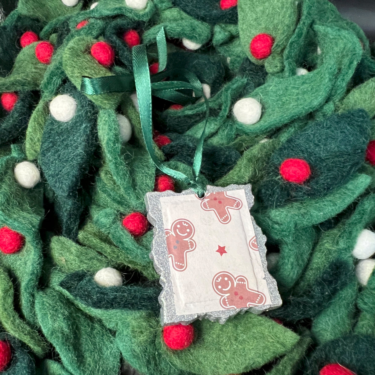 Close-up of the gingerbread man's textured sugar glaze and embossed detailing on its smiling face and button decorations.